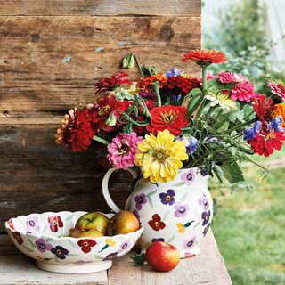 jug with flowers and fruit bowl with apple