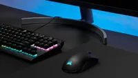 Corsair Sabre RGB Pro Wireless sitting on desk with keyboard