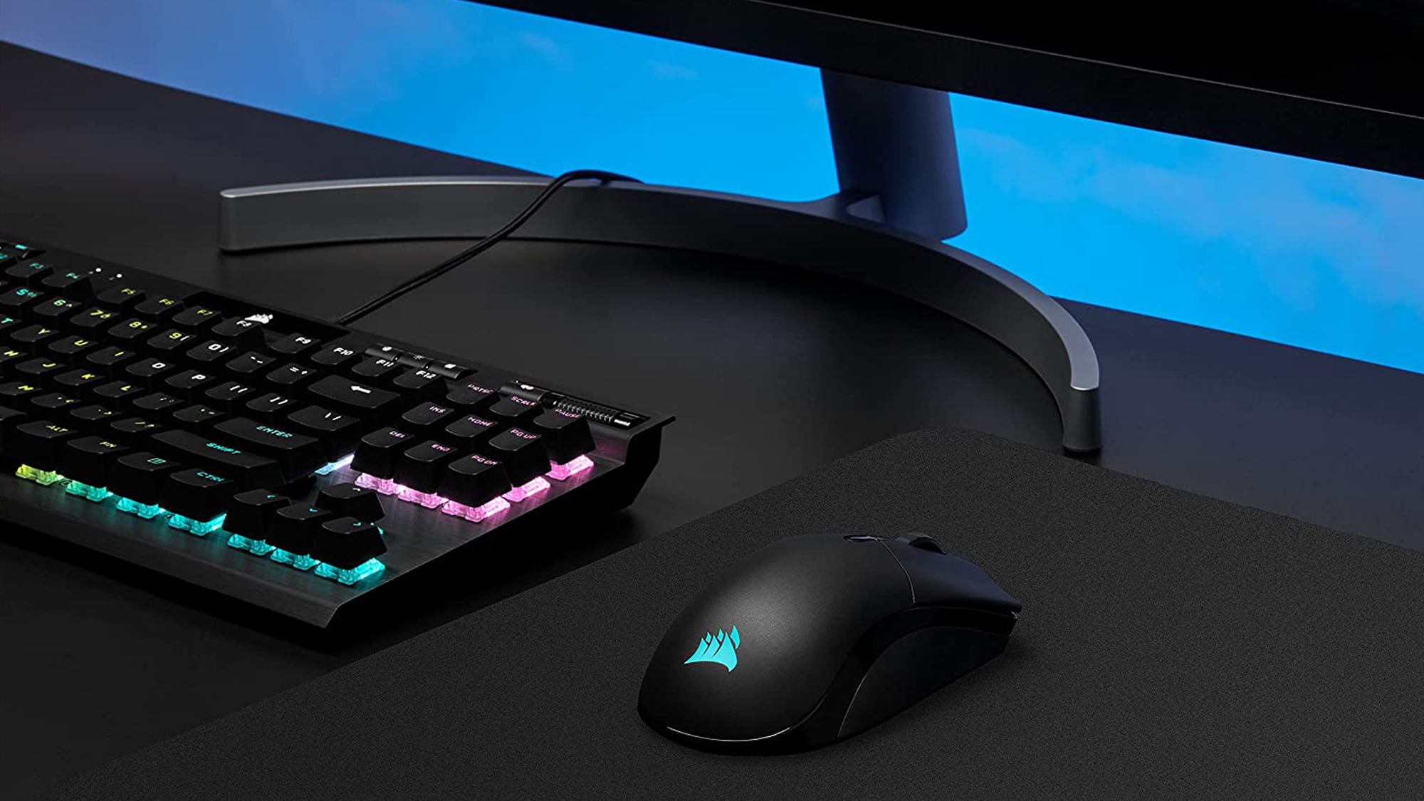 Corsair Sabre RGB Pro Wireless sitting on desk with keyboard