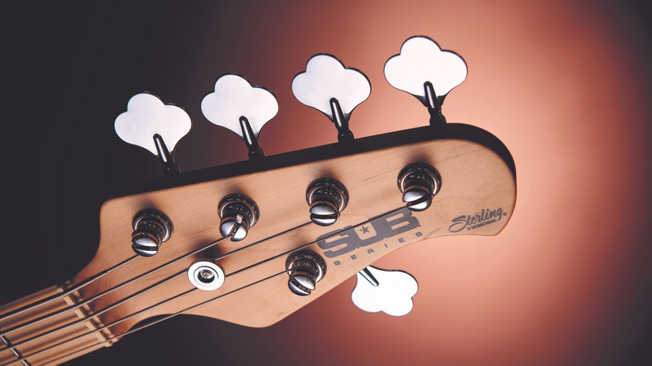Sterling by Music Man SUB Ray5 headstock on a pink/purple background