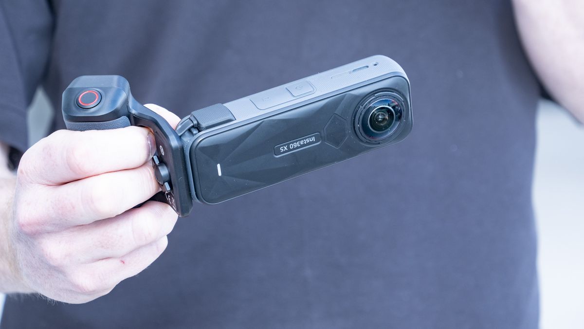 Insta360 X5 Photography Grip attached to the camera, in the hand