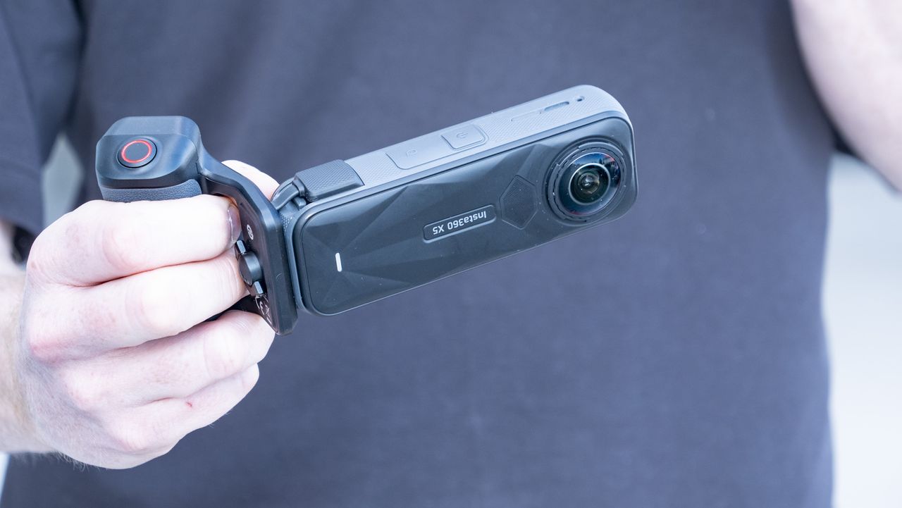 Insta360 X5 Photography Grip attached to the camera, in the hand