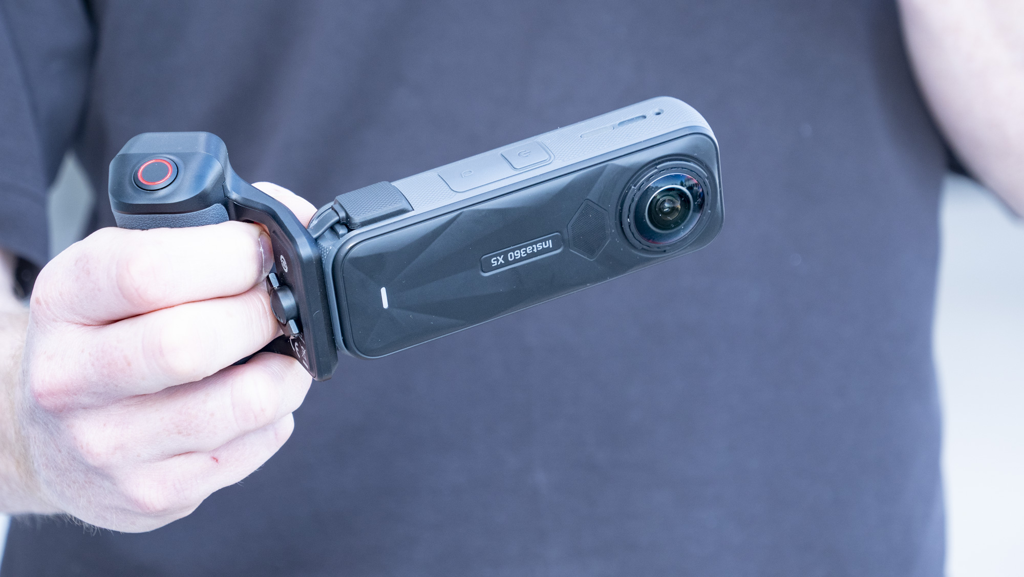 Insta360 X5 Photography Grip attached to the camera, in the hand