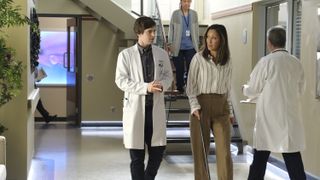Freddie Highmore and Christina Chang walk down a hallway in The Good Doctor