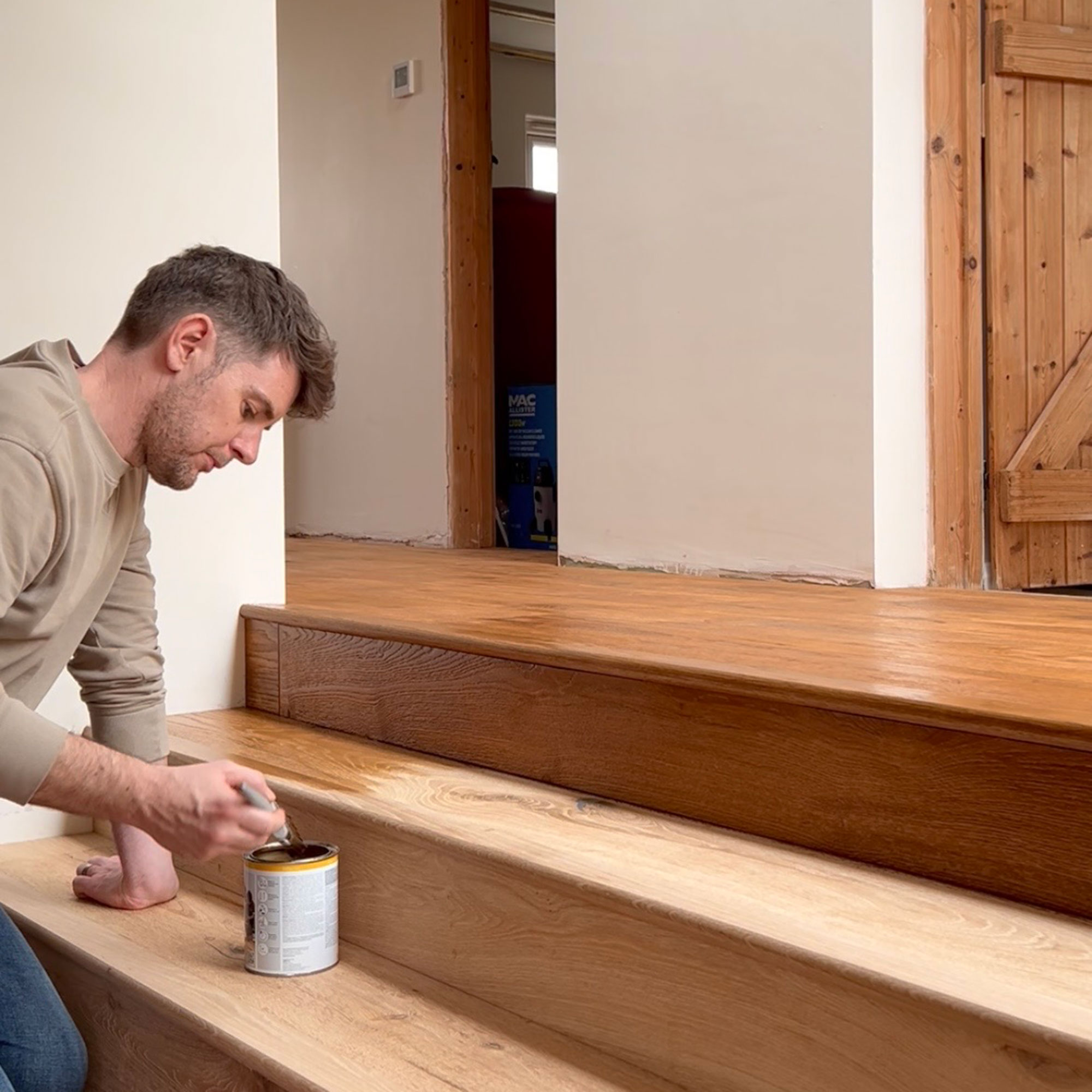 Man varnishing wooden steps