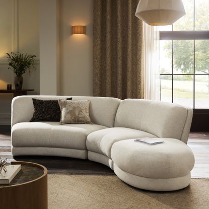 The Next Addison curved modular sofa in oyster chenille in a large living room with a round coffee table
