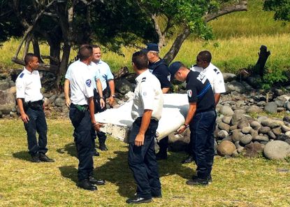 Police carry piece of debris from Malaysia Airlines flight MH370