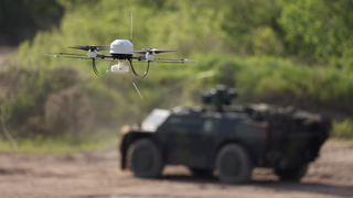 a drone flying near an armored vehicle