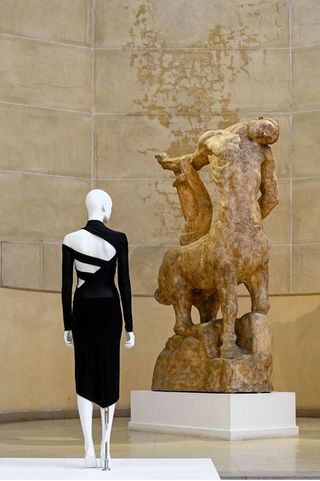 Mannequin in front of a statue