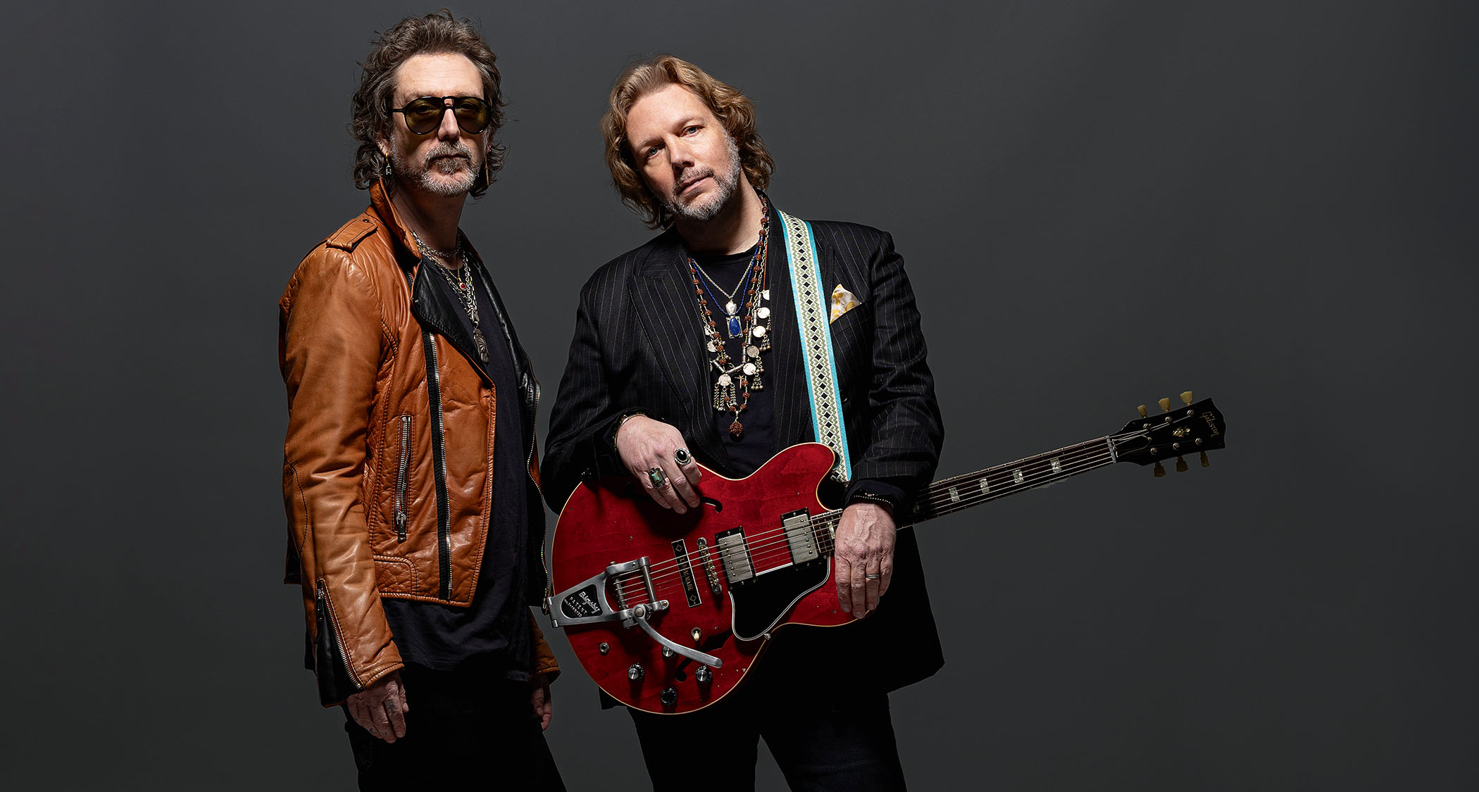 A portrait of The Black Crowes' Chris and Rich Robinson, with the latter holding his Bigsby-equipped ES-335.