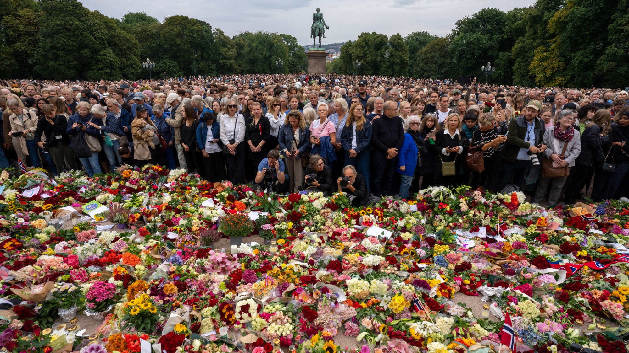 Mourners gather at a makeshift memorial of flowers to pay tribute to the late King Harald V of Norway at the Royal Palace square in Oslo