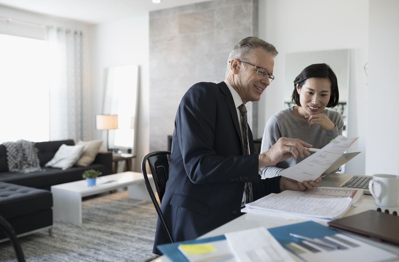 Financial advisor and woman with laptop meeting in dining room