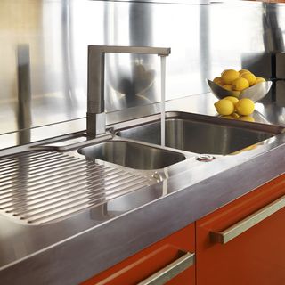 sink area with stainless steel worktop and lemons