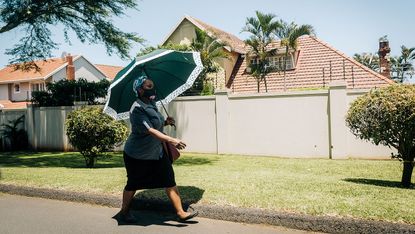 A South African woman walks through Durban wearing a mask
