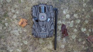 Stealth Cam Fusion Global Trail Camera laying on a stone surface