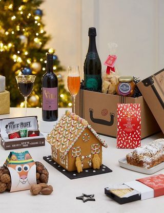 Christmas hamper with a gingerbread house and wine and nuts