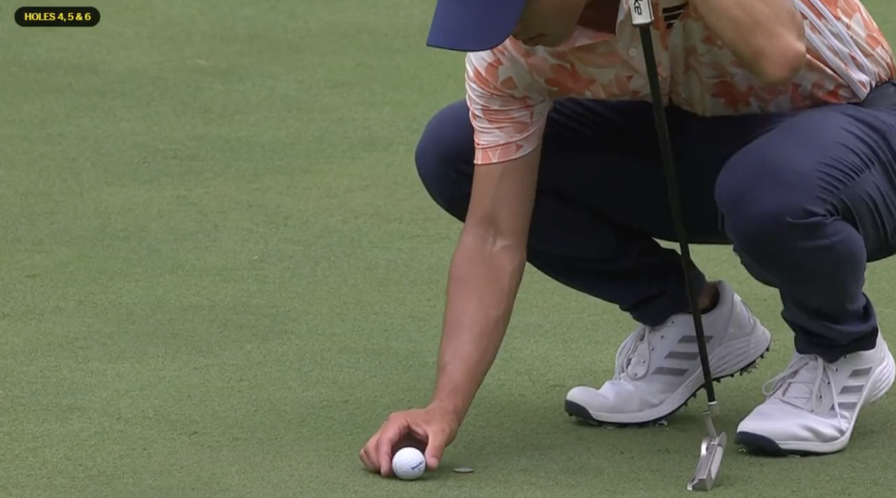 Screengrab of Collin Morikawa on the putting green replacing his ball