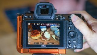 Rear LCD of Nikon Z6 II showing live view with focus peaking activated, and used to focus on a spread of scones and jam