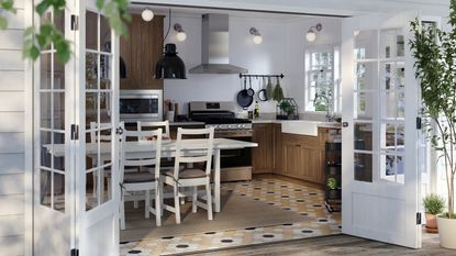 A wooden IKEA kitchen with white walls and stainless steel appliances
