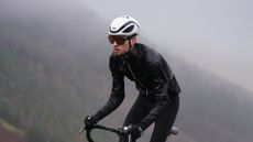Male cyclist riding in the rain wearing one of the best waterproof cycling jackets