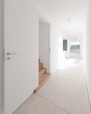 Room with white tiled flooring and staircase