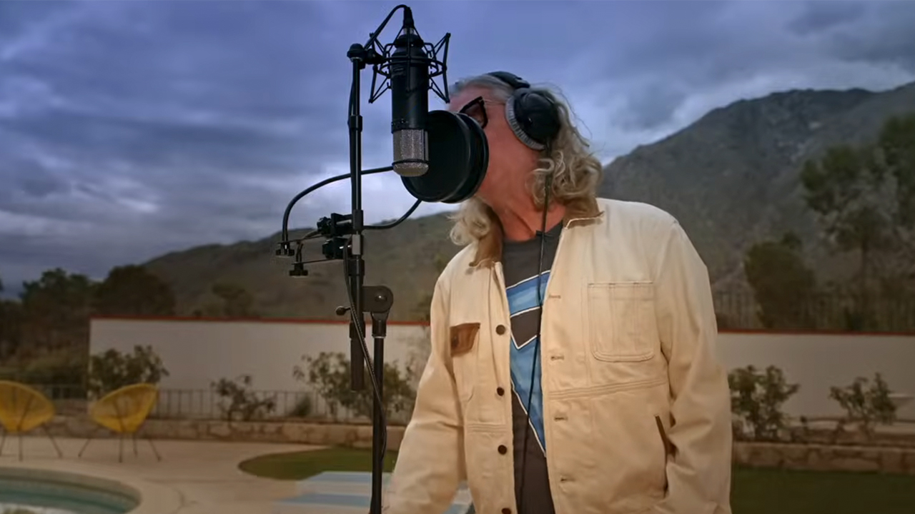 Ed Roland singing into a microphone by the pool at Elvis Presley's house in Palm Springs.