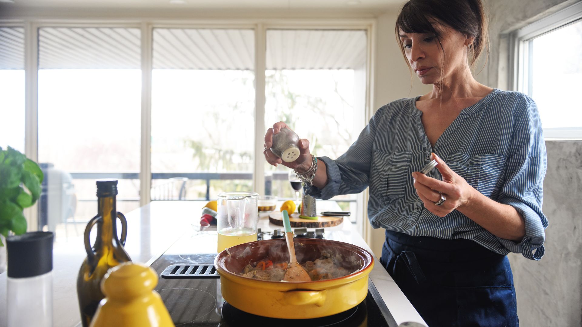 woman seasoning a pan of food