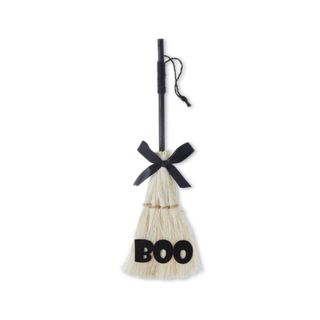 A small broom with a bow that says 