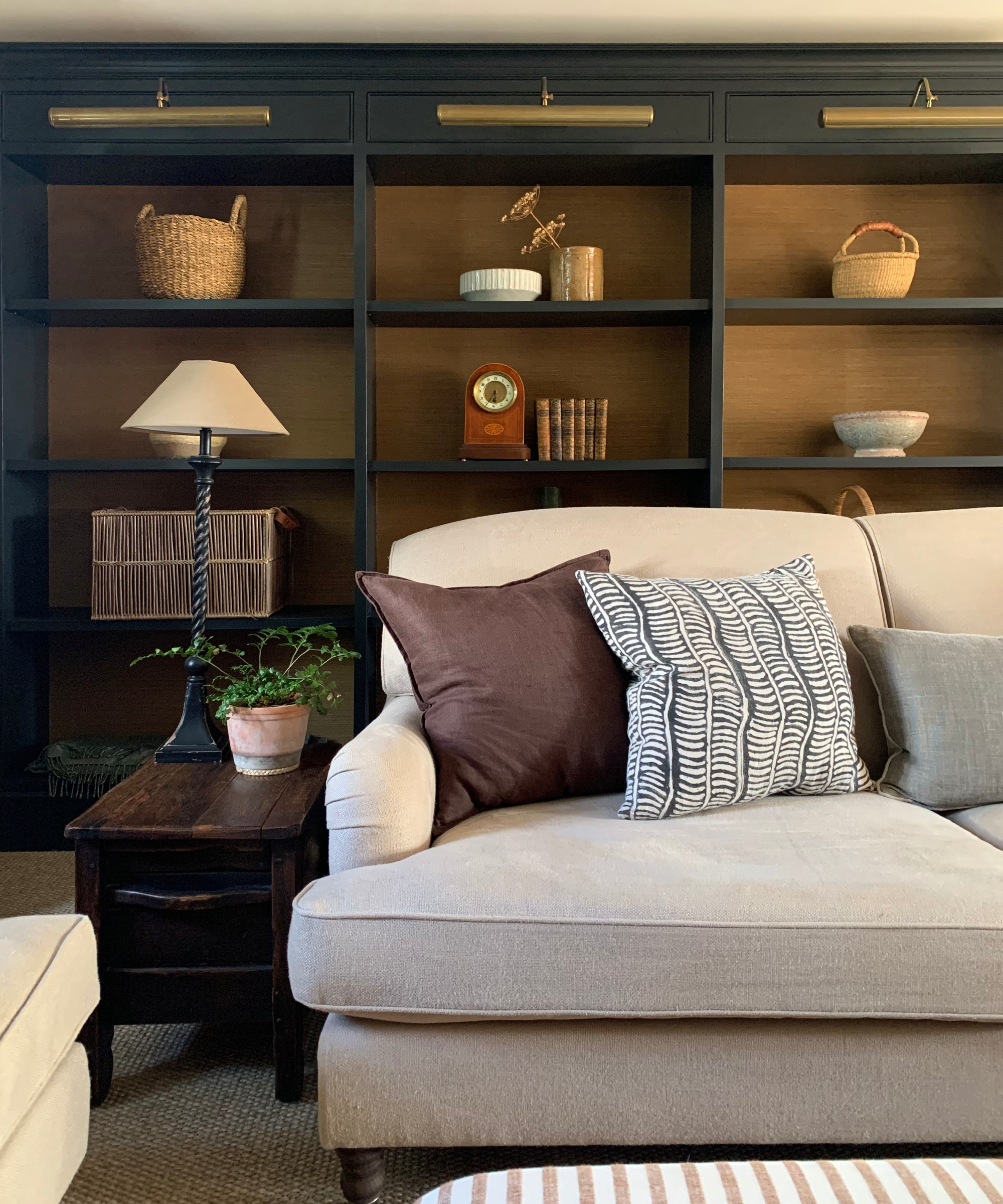 living room with built in open shelving behind cream sofa