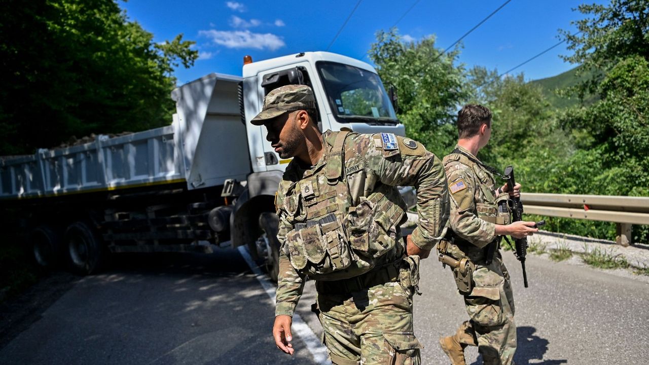 Nato soldiers serving in Kosovo patrol next to a road barricade set up by ethnic Serbs near the town of Zubin Potok