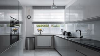 A narrow handleless kitchen in grey