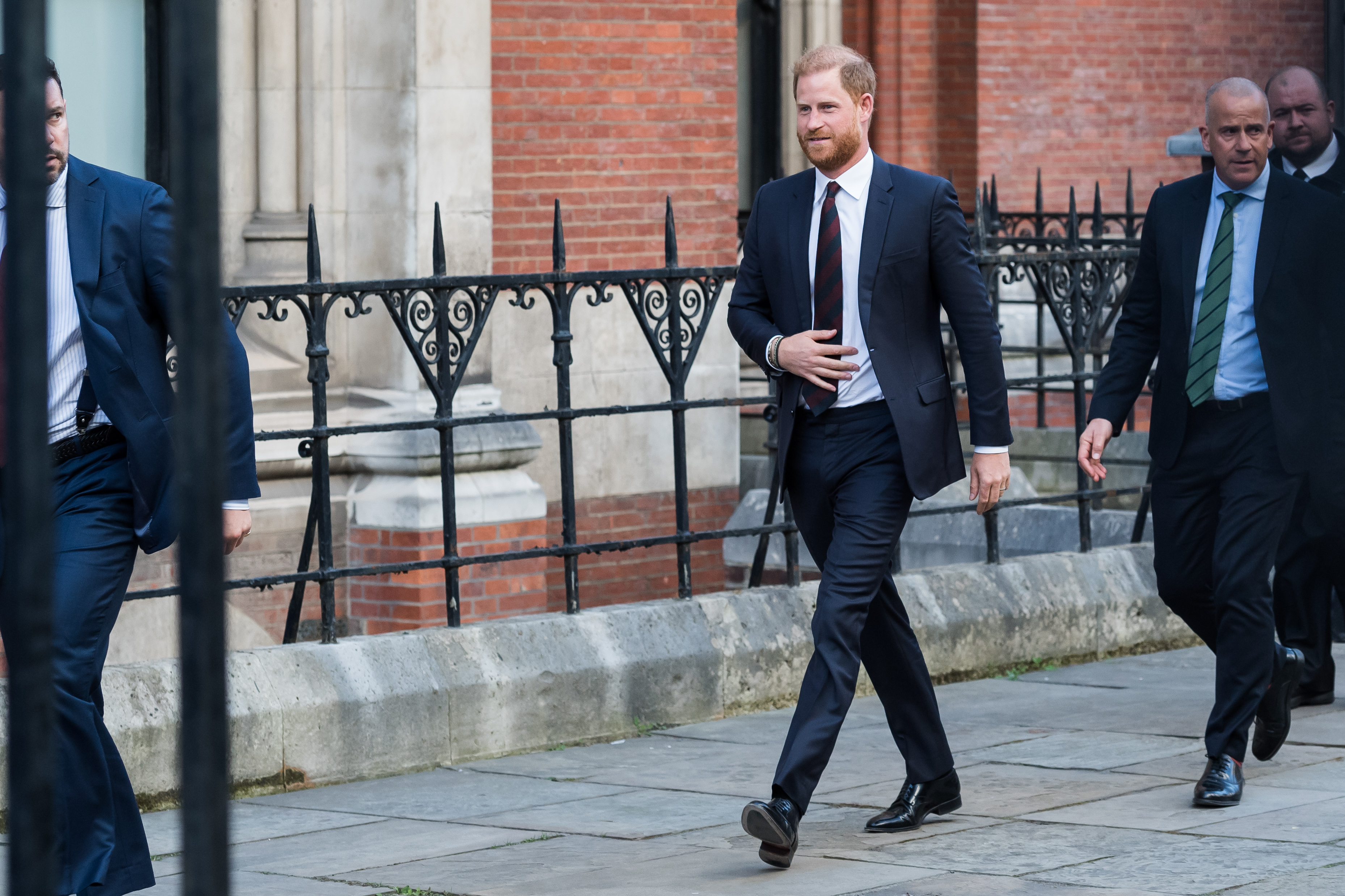 Prince Harry wearing a suit walking outside court
