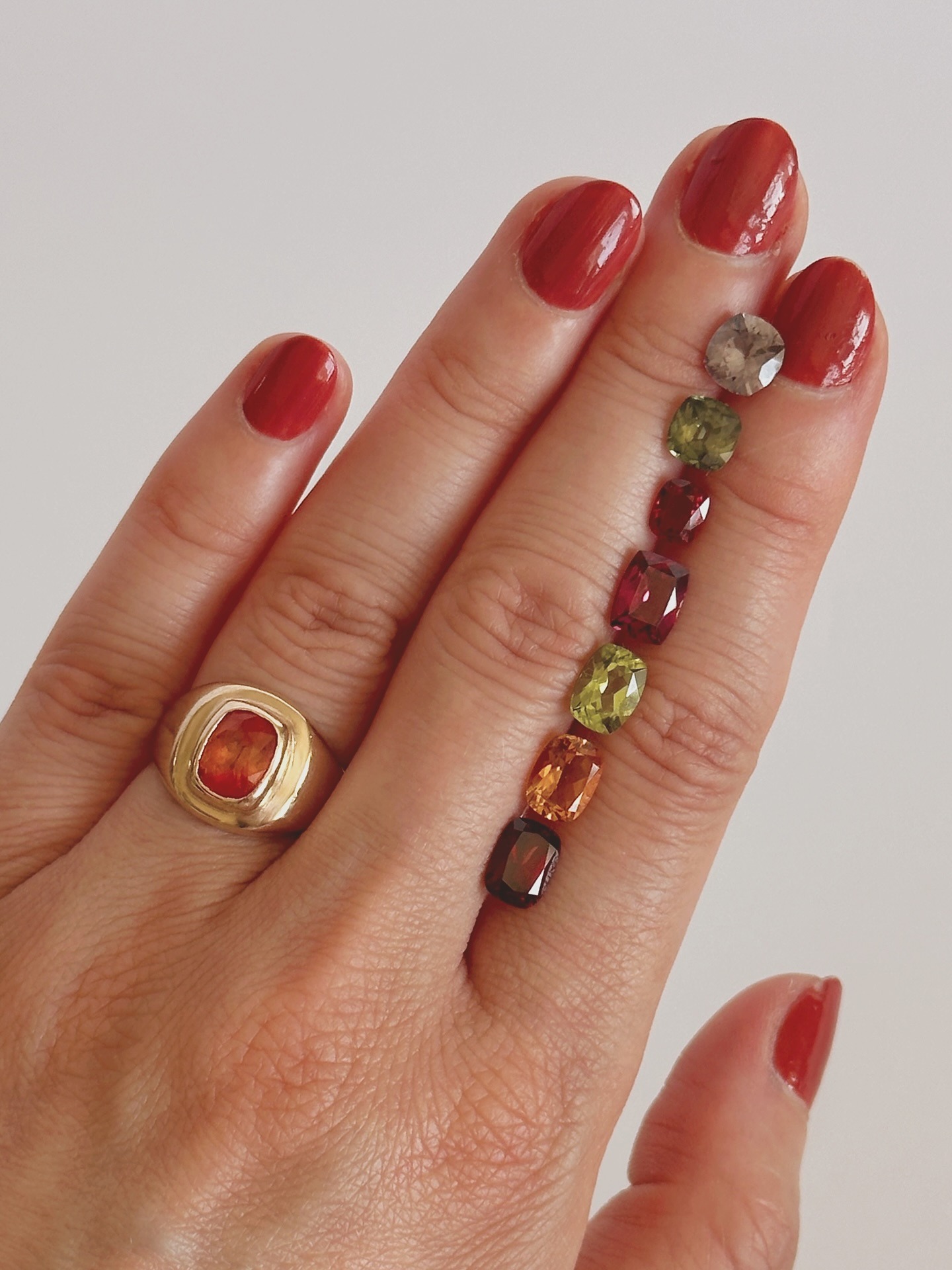 A hand holding different colored gemstones.