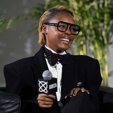 a black woman with short, honey blonde hair being interviewed on an event stage