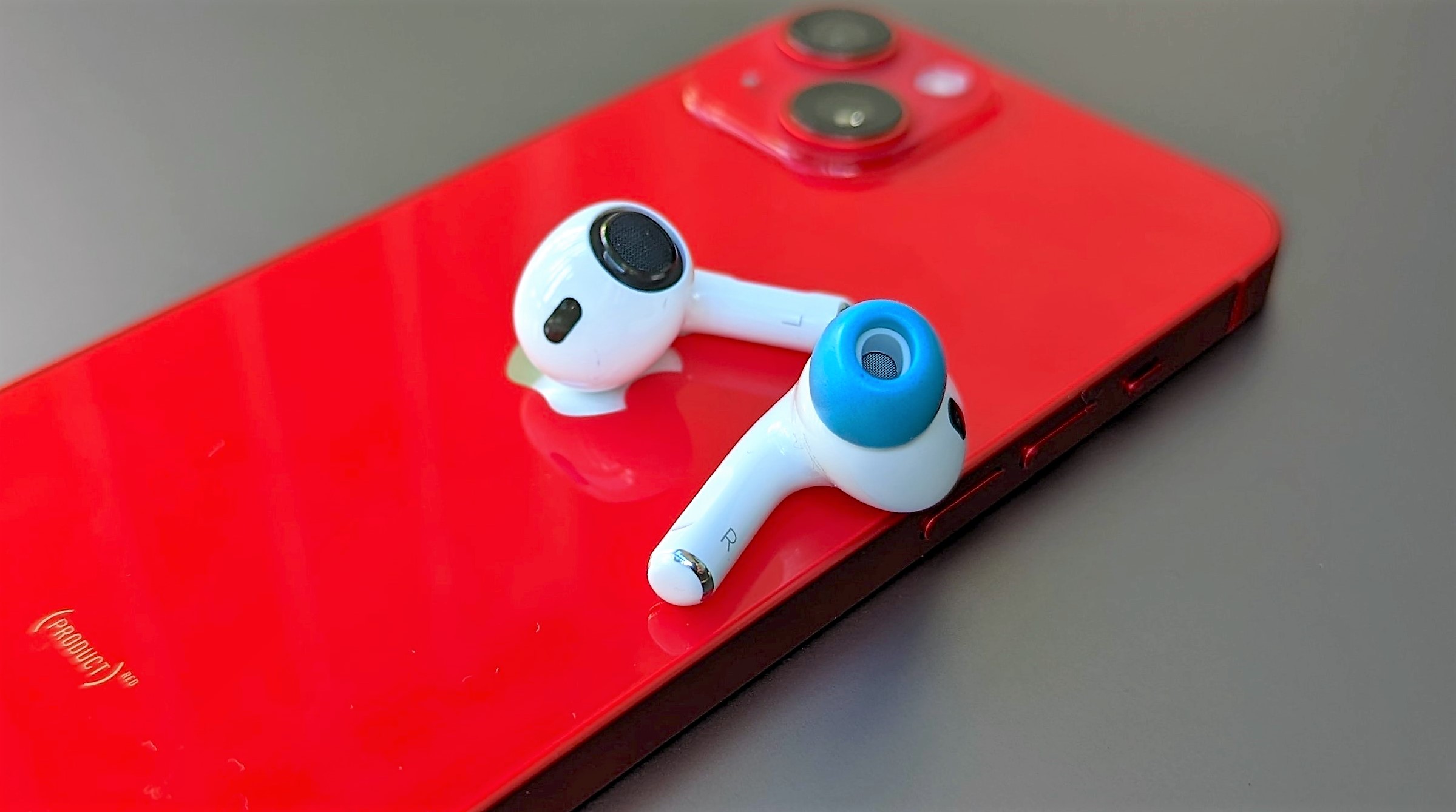 AirPods equipped with foam pads placed on top of the iPhone