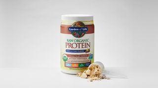 Garden of Life Raw Organic Protein tub on a table with some powder dispensed