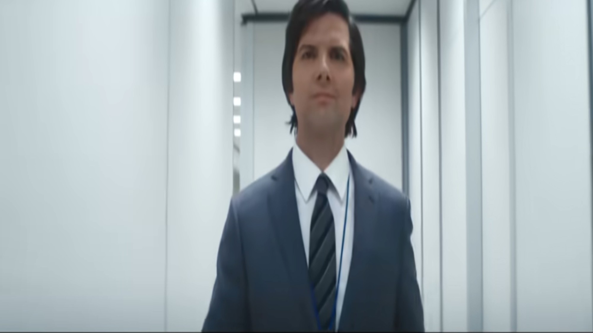 Adam Scott walking down a hallway in Severance
