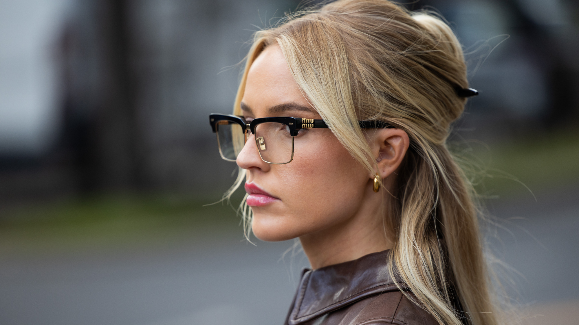 Woman wearing stylish glasses with a soft bob; frames complement warm hair tones