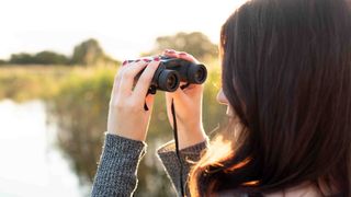 Kimberley Lane using a pair of binoculars in a nature reserve