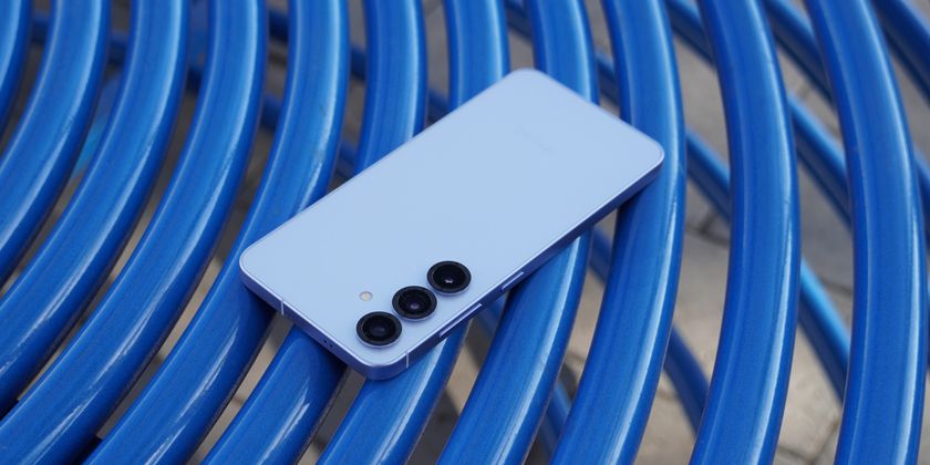 The Samsung Galaxy S25 in blue on a blue table outdoors.