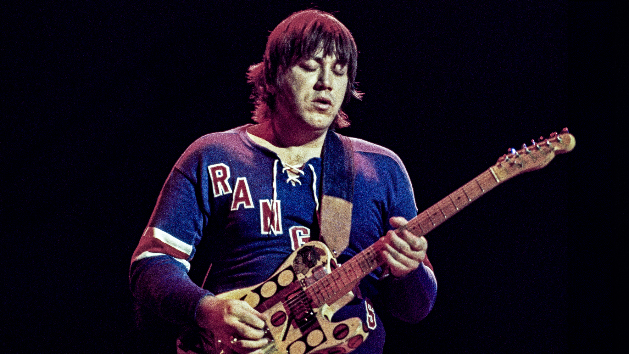 Terry Kath (1946-1978), guitarist with U.S. rock band Chicago, playing the guitar during a live concert performance at the Hammersmith Odeon in London, England, Great Britain, January 1977.