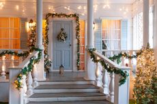 A front porch with steps, decorated with lights and Christmas decorations