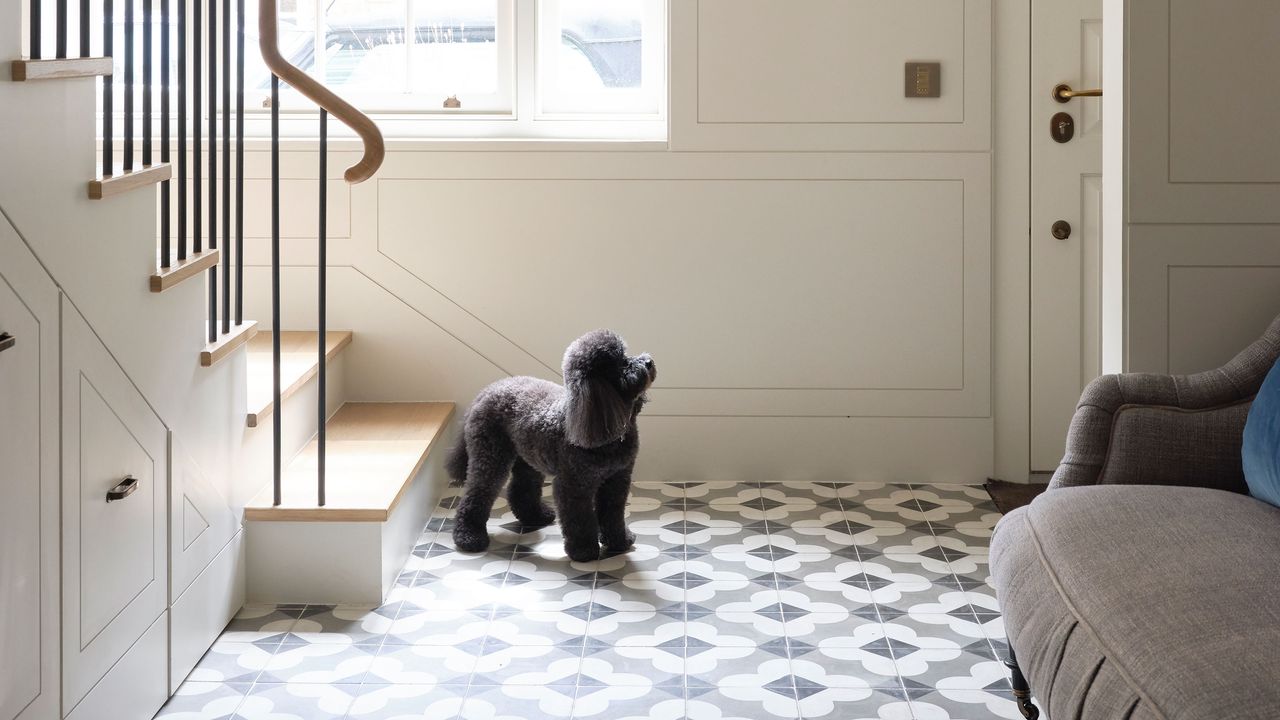 Entrance hall and staircase with monochrome flooring and cream panelled walls