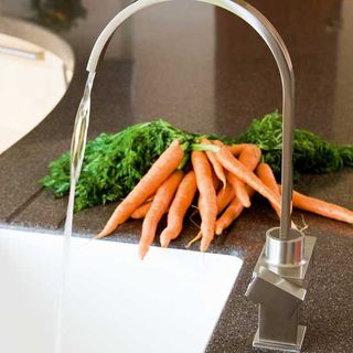 sink area tap with carrot and coriander leaves