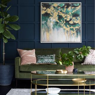 Navy colored living room with a green sofa and colored pillows and plant accessories