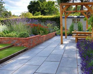 garden with black kadapha limestone paving from paving direct and pergola