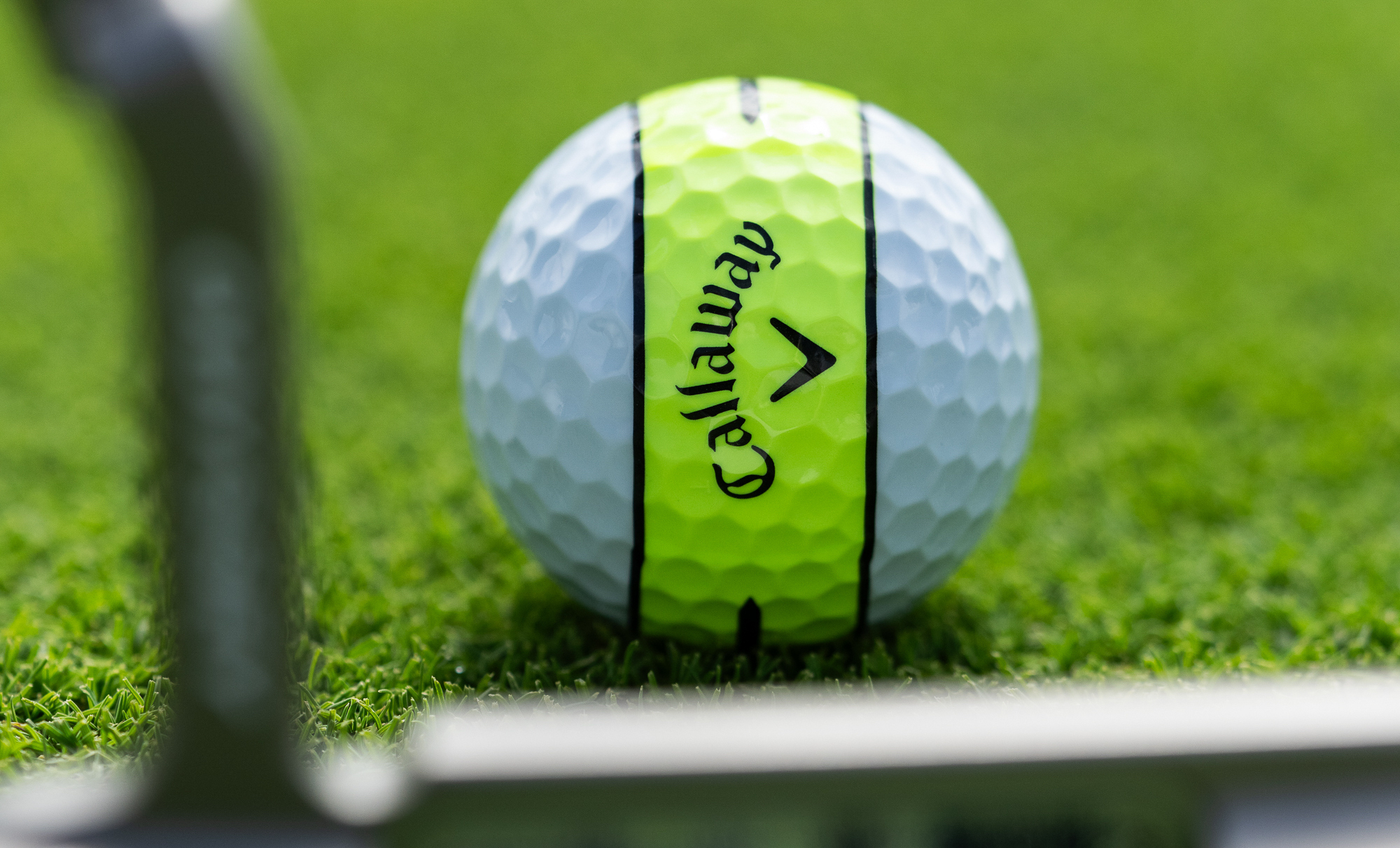 A Callaway Chrome Tour X 360 golf ball lined up in front of a putter