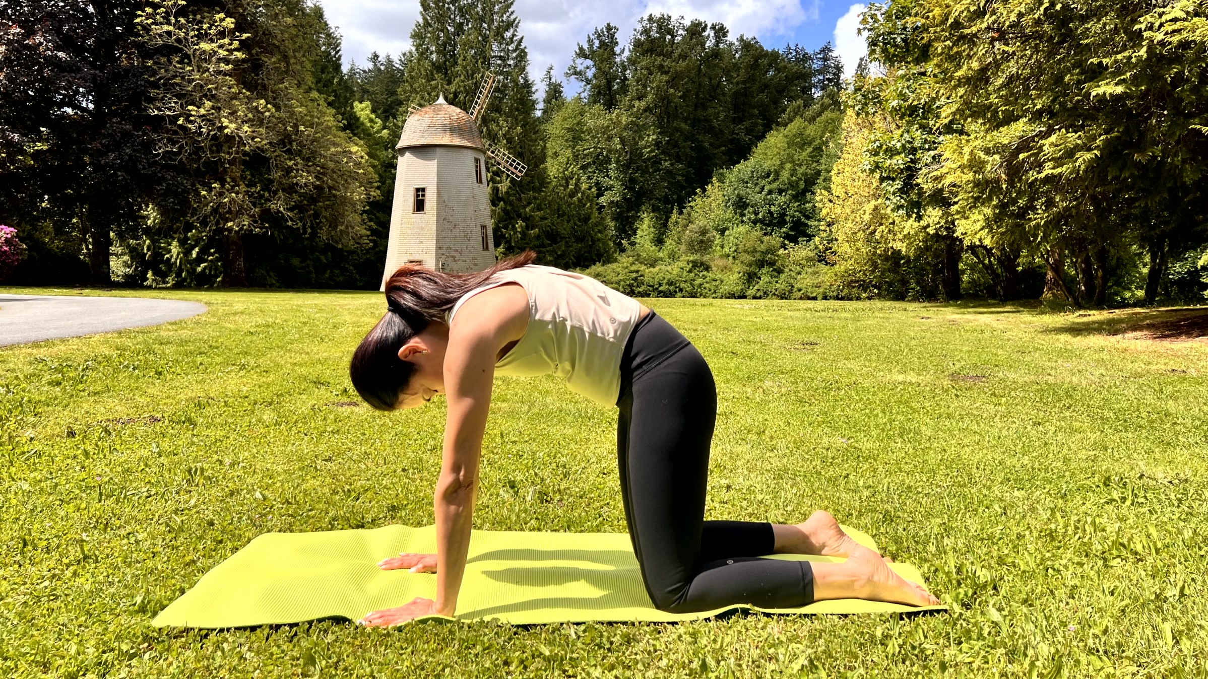Woman in yoga pose on a mat in her garden