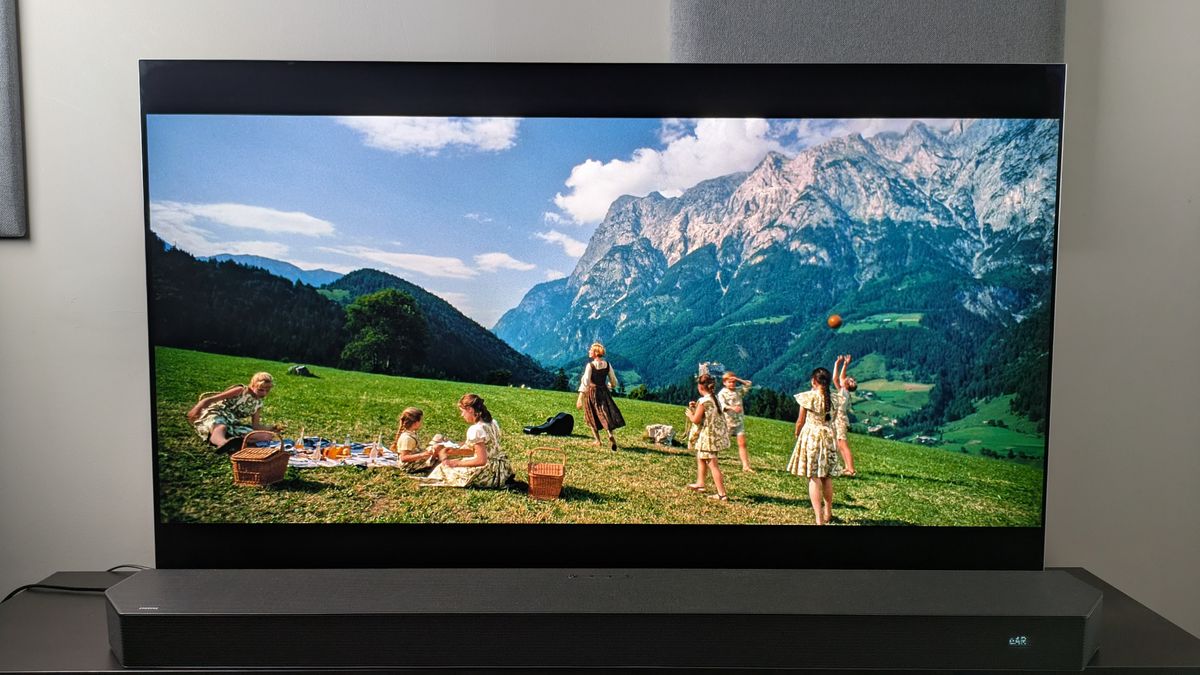 A shot of Maria and the Von Trapp children on a hillside in front of a mountain from The Sound of Music 4K Blu-ray on LG G5