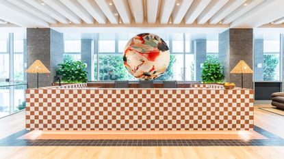 Chequered tiled counter at WeWork Singapore, with a circular artwork hanging behind